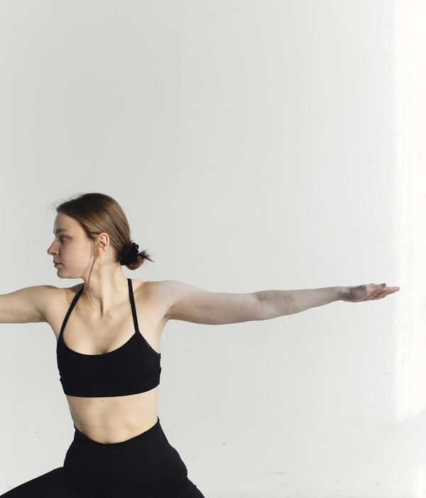 Woman holding a serene yoga pose, emphasizing back alignment in a calm studio.
